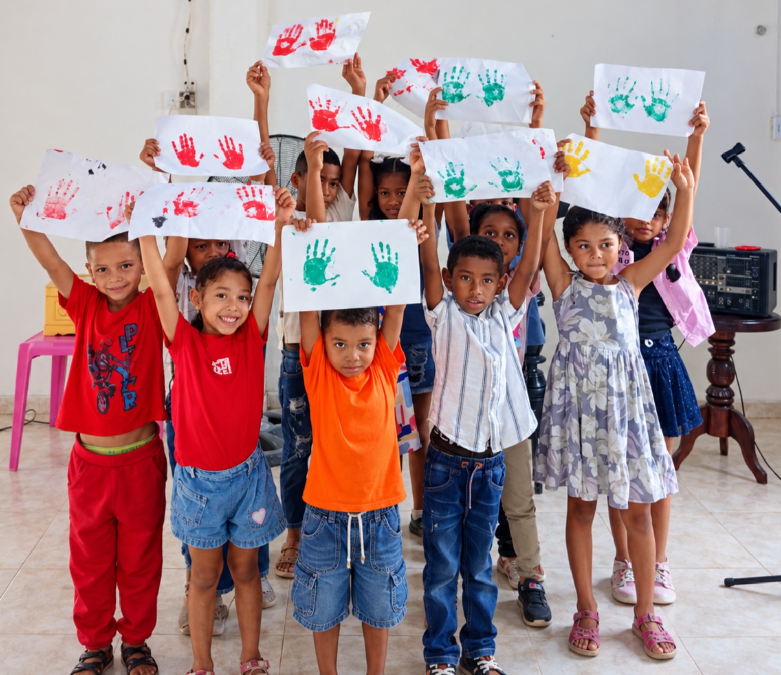 Niños de la Fundación mostrando trabajos con huellas de colores